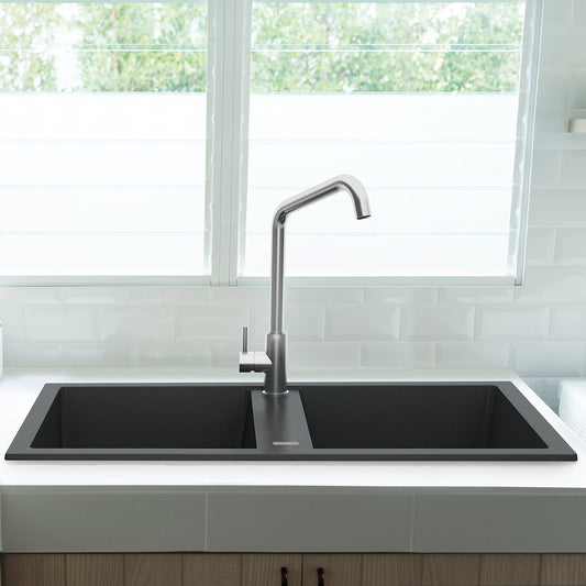 Crna mat dvodelna granitna sudopera sa crnim sifonom i drvenom daskom